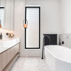 Modern bathroom with freestanding bathtub, vanity, and decorative elements.